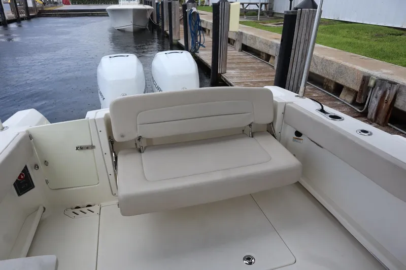 Slide: The Image of 2017 Boston Whaler 270 Vantage boat with dual engines and foldable seating at dock. - 6