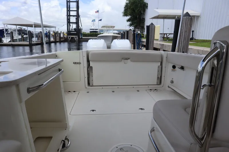 Slide: The Image of 2017 Boston Whaler 270 Vantage boat interior at marina, featuring seating and storage. - 7