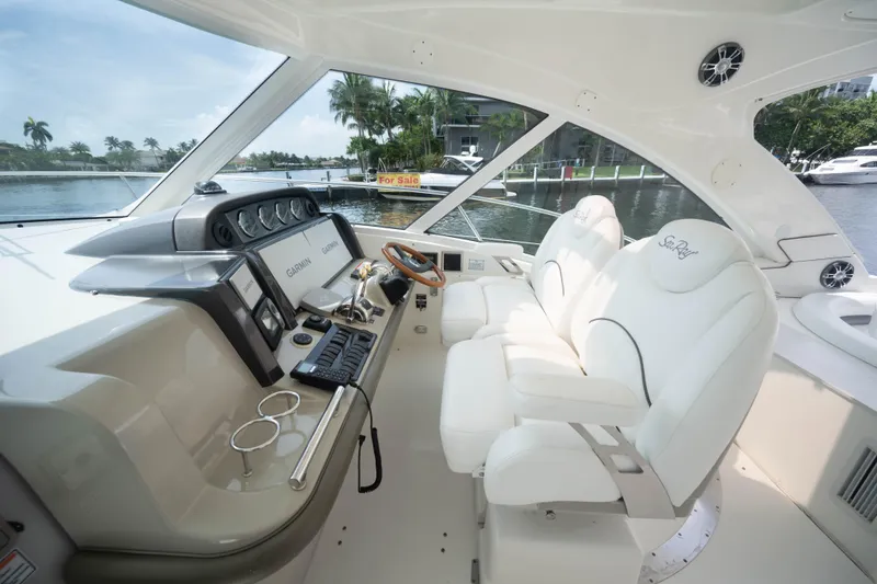 Slide: The Image of 2006 Sea Ray 48 Sundancer helm with white seating and advanced navigation systems. - 12