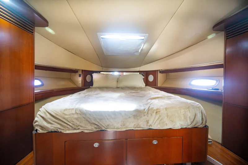 Slide: The Image of Luxurious cabin interior of 2006 Sea Ray 48 Sundancer yacht with cozy bed and wooden accents. - 17