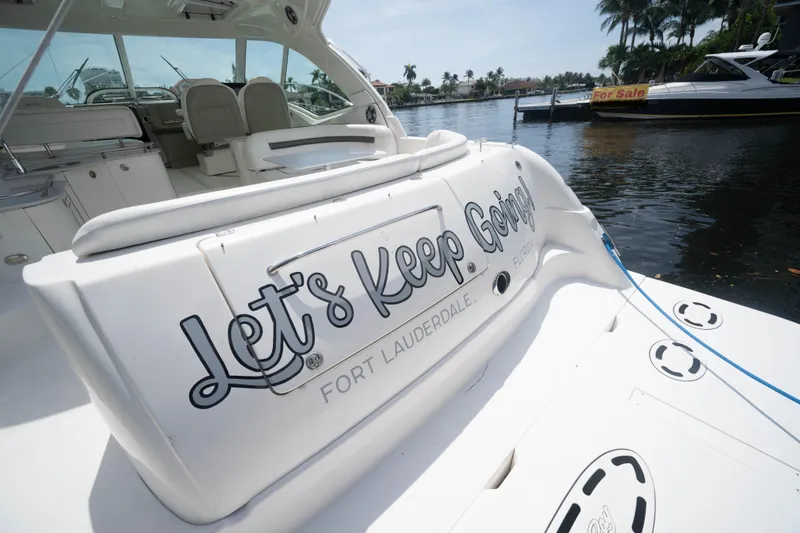 Slide: The Image of 2006 Sea Ray 48 Sundancer yacht with "Let's Keep Going" text, docked in Fort Lauderdale. - 2