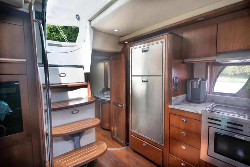 Slide: The Image of Interior of 2006 Sea Ray 48 Sundancer yacht with modern kitchen and wooden stairs. - 20