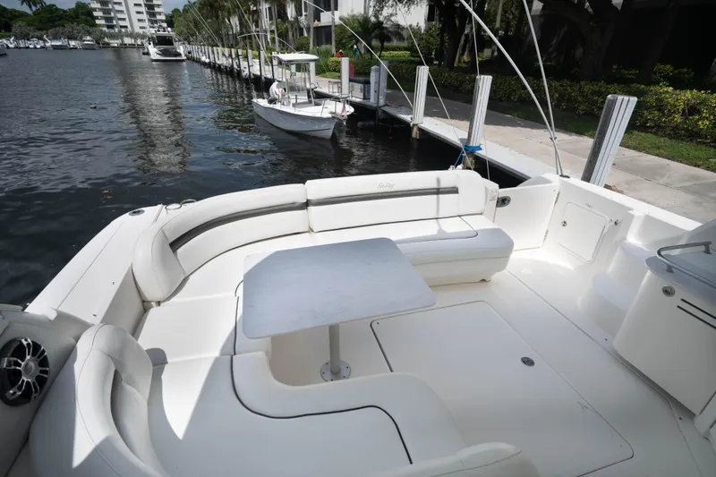 Slide: The Image of 2006 Sea Ray 48 Sundancer yacht with spacious seating and table, docked by the water. - 4
