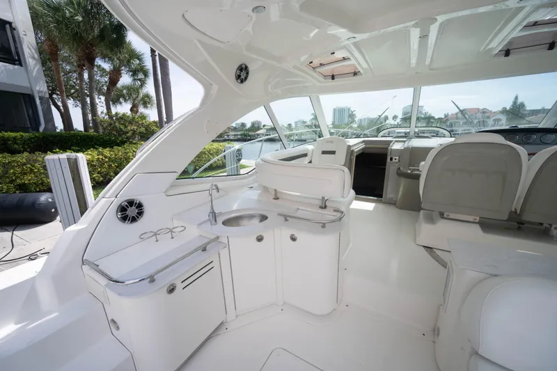 Slide: The Image of 2006 Sea Ray 48 Sundancer yacht interior with helm, seating, and kitchenette. - 5