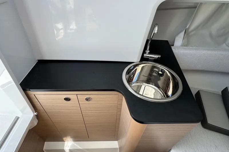 Slide: The Image of 2026 Jeanneau Leader WA 7.5 boat interior with sleek sink and wooden cabinetry. - 21