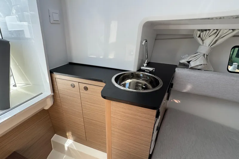 Slide: The Image of 2026 Jeanneau Leader WA 7.5 interior with compact kitchenette and modern design. - 23