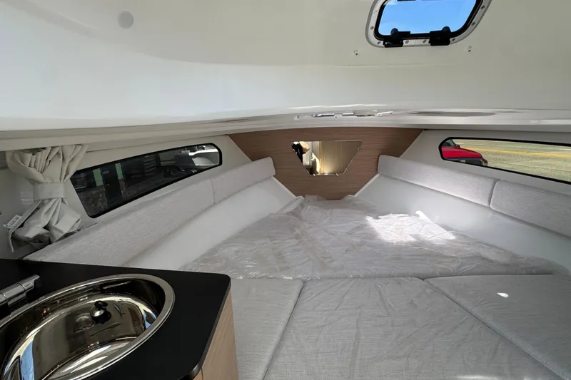 Slide: The Image of Interior of 2026 Jeanneau Leader WA 7.5 boat, featuring cozy cabin and sink. - 26