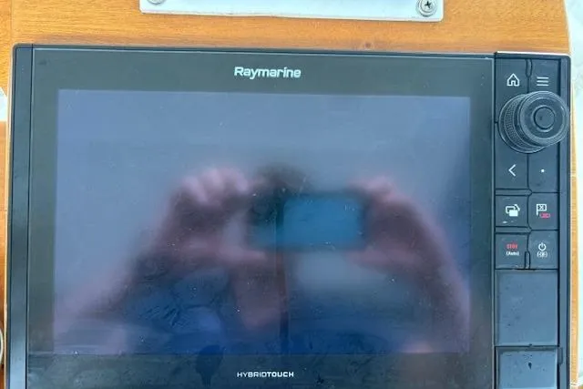 Slide: The Image of 2006 Intrepid 310 Walkaround helm with steering wheel, gauges, and Raymarine navigation system. - 19