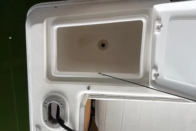 Slide: The Image of 2006 Intrepid 310 Walkaround boat interior with seating and storage compartments. - 24