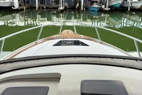 Slide: The Image of 2006 Intrepid 310 Walkaround boat storage compartment with open hatch and rod holder. - 25