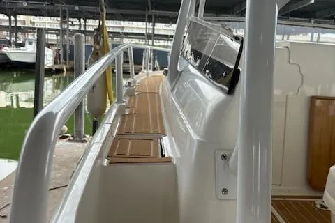 Slide: The Image of 2006 Intrepid 310 Walkaround boat deck with wood finish and Intrepid logo. - 27