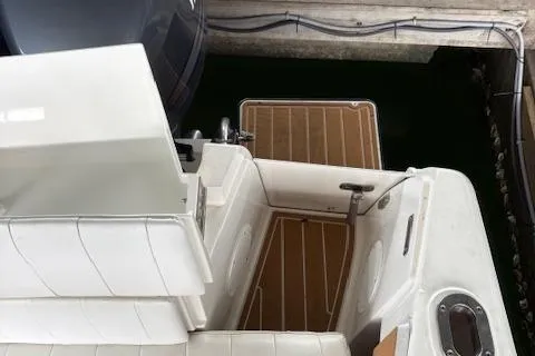 Slide: The Image of 2006 Intrepid 310 Walkaround boat interior with wooden deck, docked in a marina. - 28