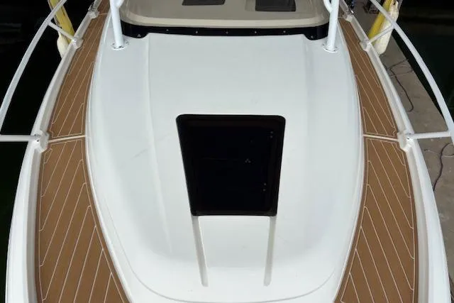 Slide: The Image of 2006 Intrepid 310 Walkaround boat with spacious deck and sleek design in marina. - 39