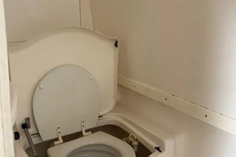 Slide: The Image of 2006 Intrepid 310 Walkaround boat bathroom interior with white marine toilet. - 50