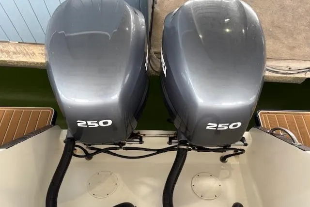 Slide: The Image of 2006 Intrepid 310 Walkaround boat docked with fenders, showcasing sleek design. - 6