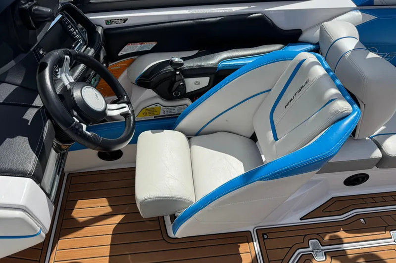 Slide: The Image of 2015 Nautique Super Air Nautique G25 cockpit with blue and white seating, steering wheel, and controls. - 10