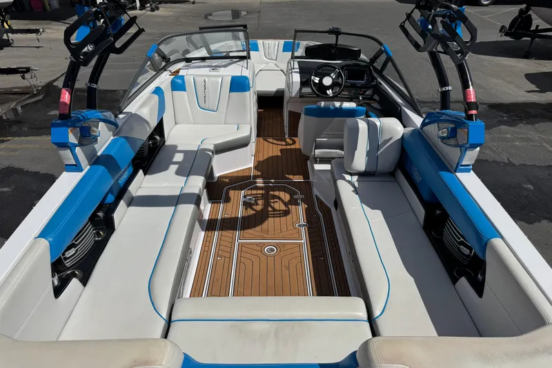 Slide: The Image of 2015 Nautique Super Air Nautique G25 interior with blue and white seating, wooden flooring. - 7