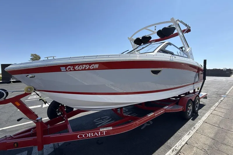 Slide: The Image of 2021 Cobalt R6 Surf boat on trailer, red and white design, parked outdoors. - 4