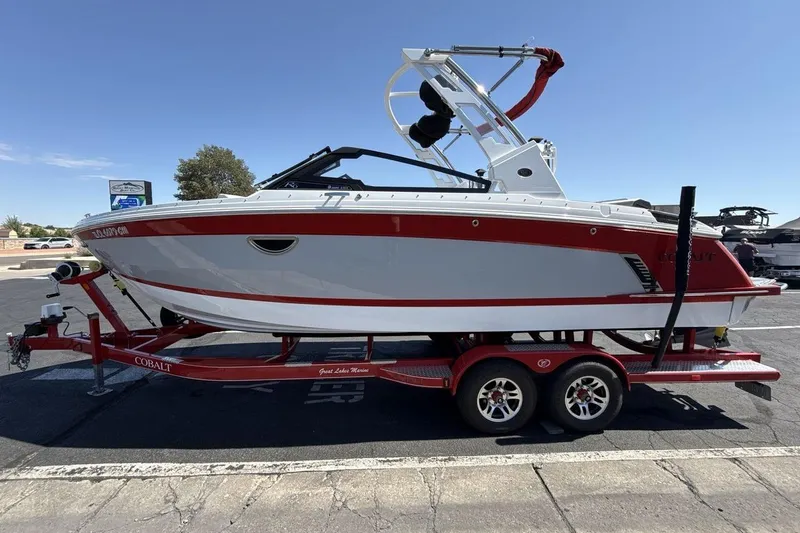 Slide: The Image of 2021 Cobalt R6 Surf boat on trailer, red and white design, parked outdoors. - 5