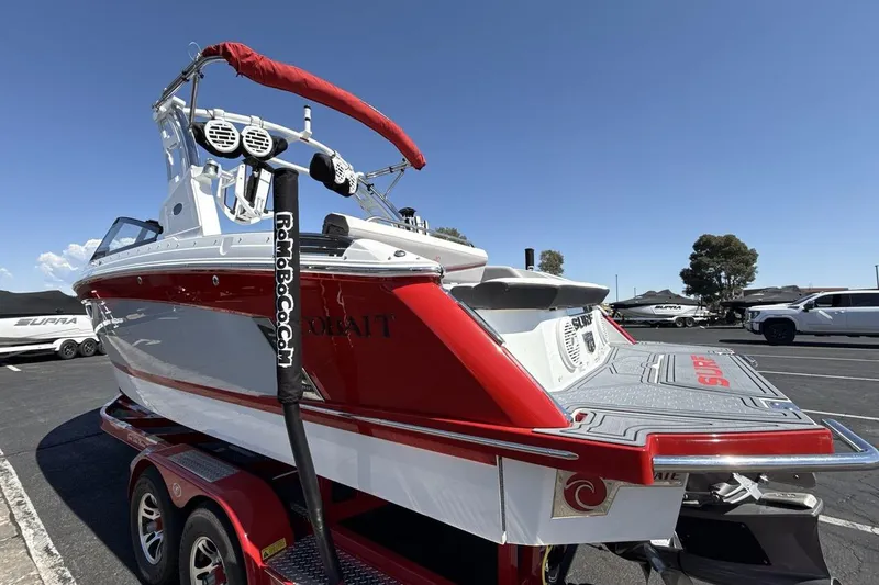 Slide: The Image of 2021 Cobalt R6 Surf boat on trailer, red and white design, parked outdoors. - 6