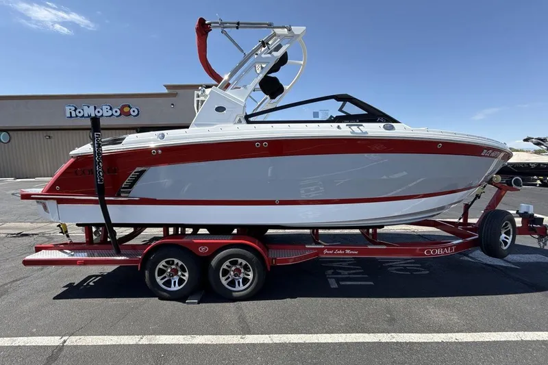 Slide: The Image of 2021 Cobalt R6 Surf boat on red trailer, parked outdoors under clear sky. - 9