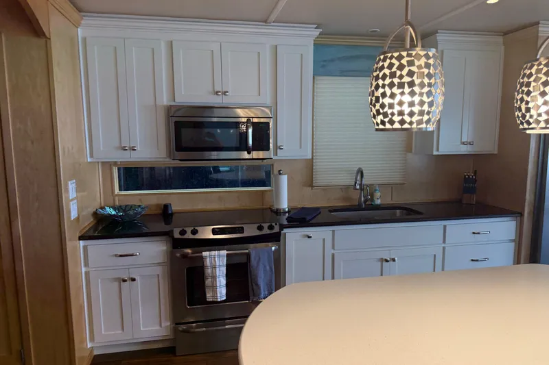 Slide: The Image of Modern kitchen with white cabinets, stainless steel appliances, and decorative pendant lighting. STARDUST Oceans Share #2, 2015. - 14