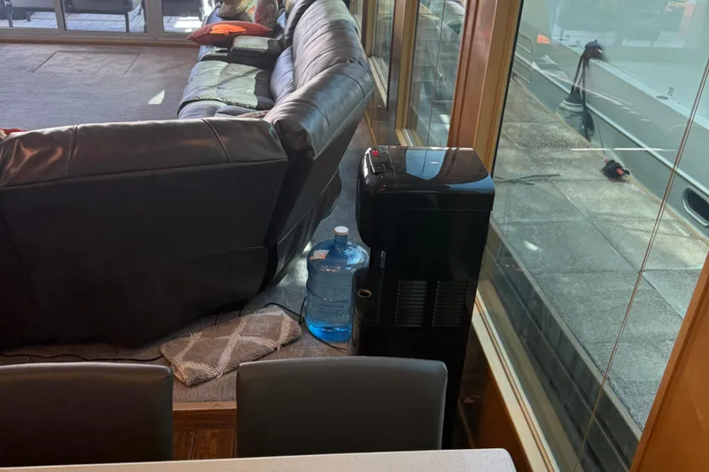 Slide: The Image of Luxurious interior of STARDUST Oceans Share #2 houseboat, featuring leather sofa and water dispenser. - 15