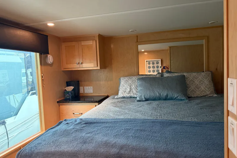 Slide: The Image of Cozy bedroom in 2015 STARDUST Oceans Share #2 houseboat with blue bedding and wooden cabinetry. - 37