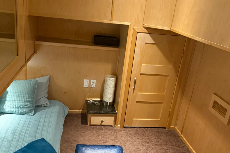 Slide: The Image of Cozy bedroom with wooden walls, blue bedding, and a small nightstand in STARDUST Oceans Share #2, 2015. - 42