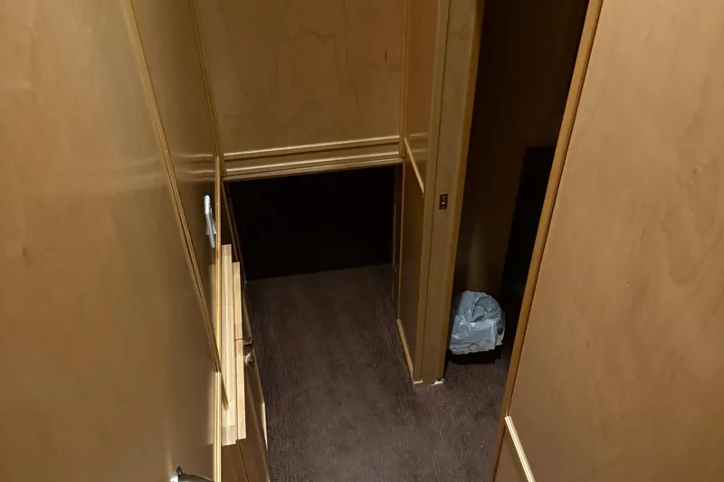 Slide: The Image of Narrow wooden hallway with stairs, featuring a small trash bin. STARDUST Oceans Share #2, 2015. - 45