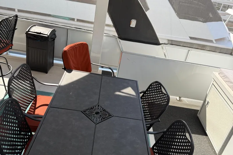 Slide: The Image of Outdoor seating area on a STARDUST Oceans Share #2, 2015 model, with black table and chairs. - 77