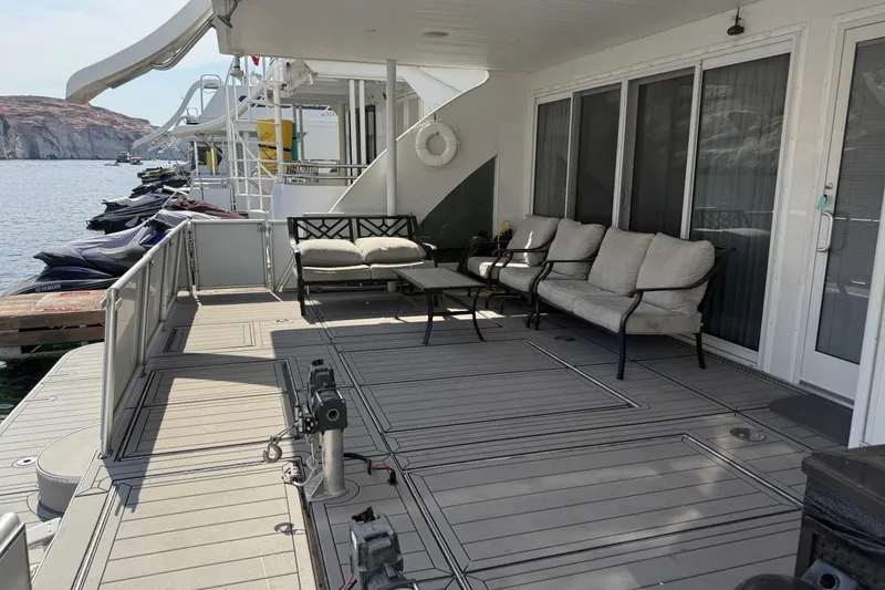 Slide: The Image of Spacious deck of STARDUST Oceans Share #2 houseboat with comfortable seating, overlooking serene waters. - 8
