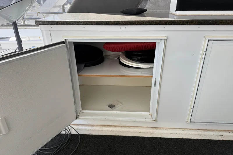 Slide: The Image of Open storage compartment on STARDUST Oceans Share #2 boat, showing interior shelves and items. - 92