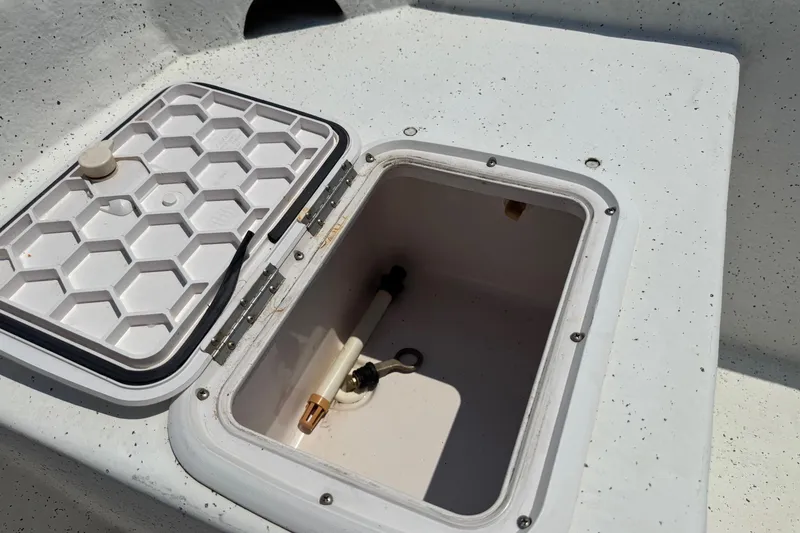 Slide: The Image of Open storage compartment on 2011 Pro-Line 20 CC boat, featuring a hexagonal lid design. - 10