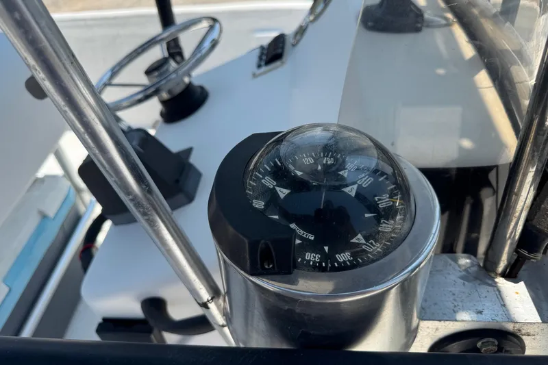 Slide: The Image of 2011 Pro-Line 20 CC boat dashboard with compass and steering wheel. - 13