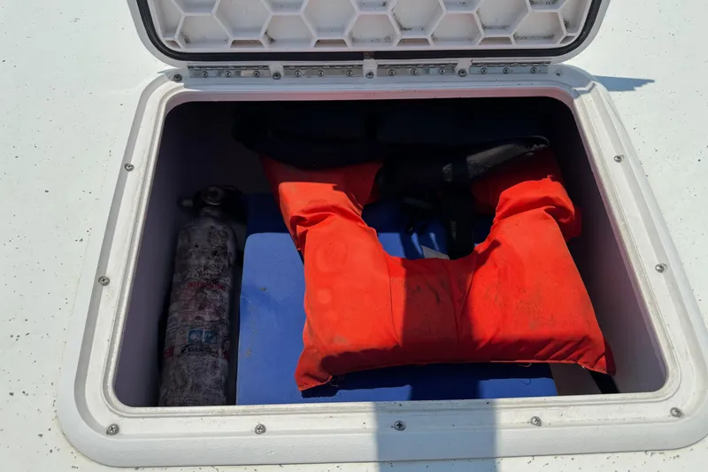 Slide: The Image of Storage compartment on 2011 Pro-Line 20 CC boat with life jacket and fire extinguisher. - 18