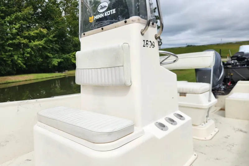 Slide: The Image of 2008 May-Craft 1800 Skiff boat interior with seating and steering console near a serene waterway. - 9