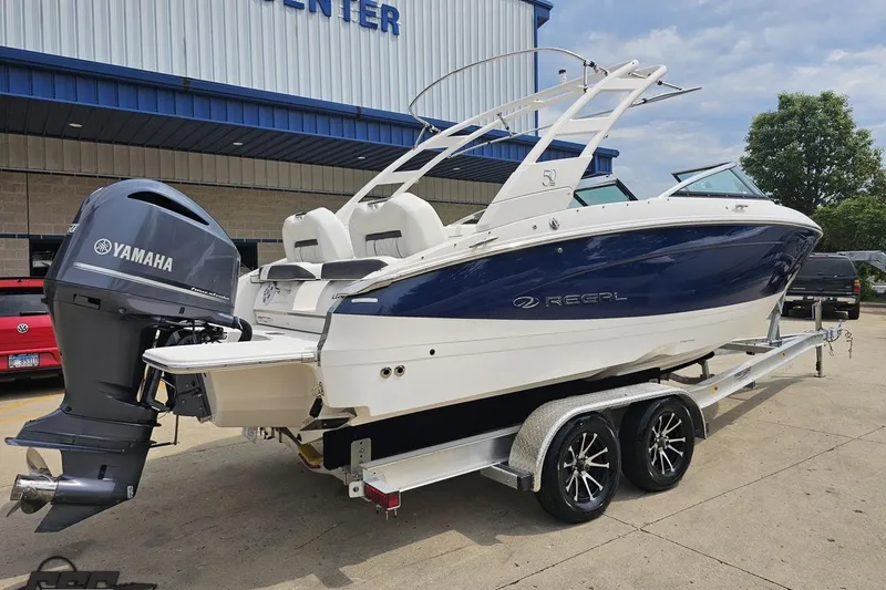 Slide: The Image of 2021 Regal LX4 boat with Yamaha engine on trailer, parked outside a building. - 11