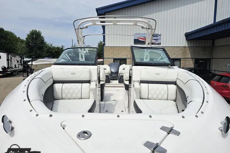 Slide: The Image of 2021 Regal LX4 boat with white seating, docked near a building. - 16