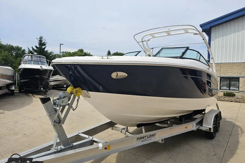 Slide: The Image of 2021 Regal LX4 boat on trailer, parked outdoors near other boats. - 17