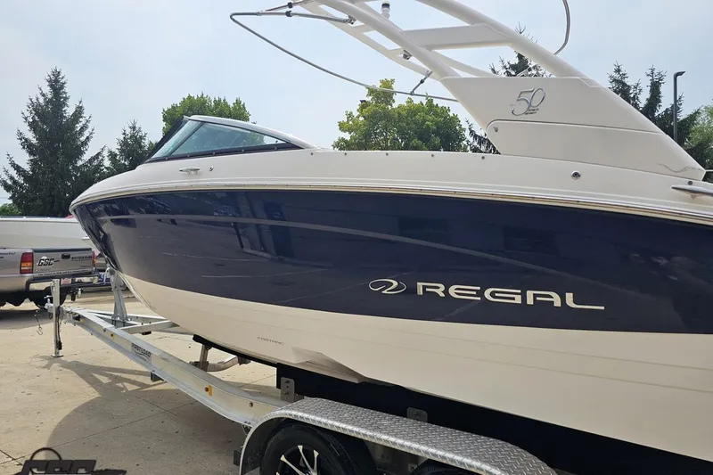 Slide: The Image of 2021 Regal LX4 boat on trailer, sleek design, blue and white exterior. - 22