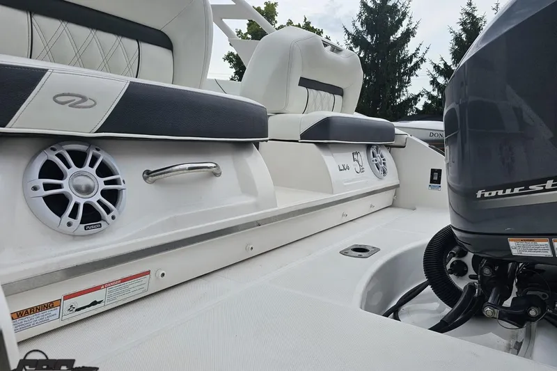 Slide: The Image of 2021 Regal LX4 boat interior with speakers and four-stroke engine, featuring luxury seating. - 27