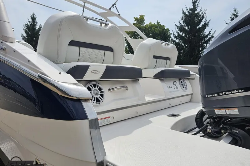 Slide: The Image of 2021 Regal LX4 boat interior with white seating and powerful four-stroke engine. - 30
