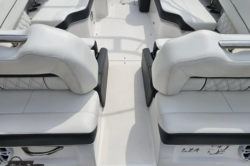 Slide: The Image of Interior seating of a 2021 Regal LX4 boat, featuring white and black upholstery. - 34