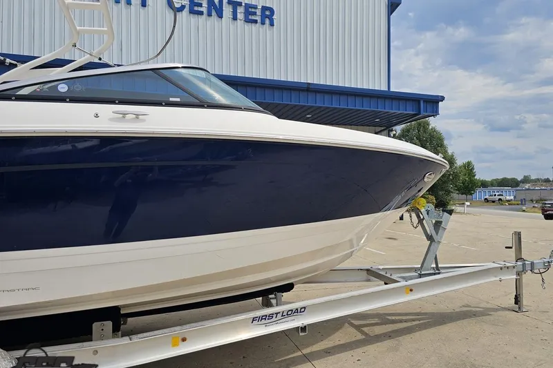 Slide: The Image of 2021 Regal LX4 boat on trailer outside a marine center. - 4