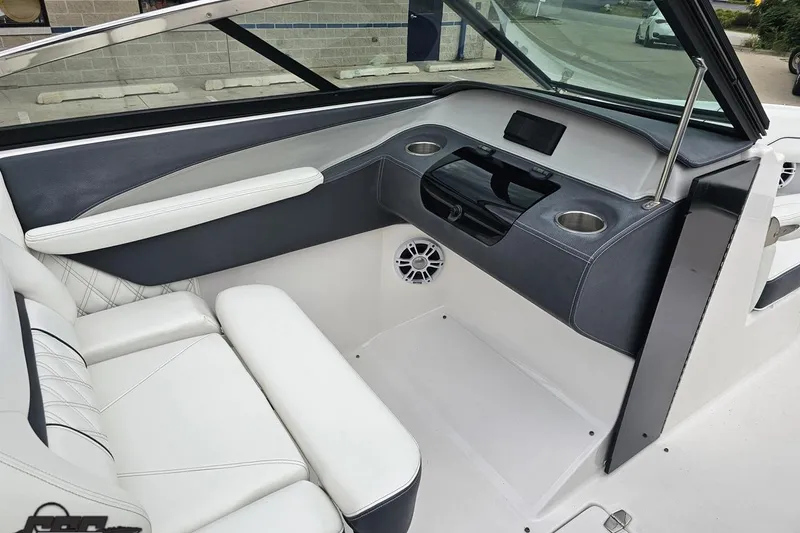Slide: The Image of 2021 Regal LX4 boat interior with white seating, dashboard, and cup holders. - 52