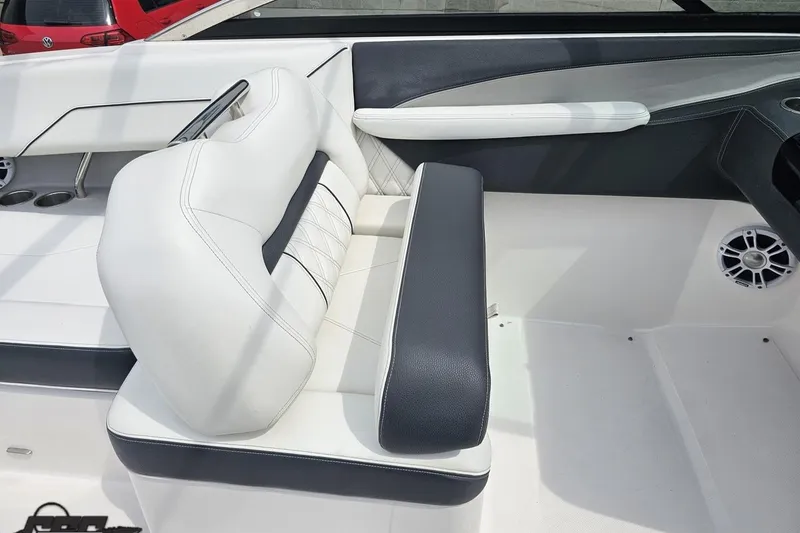 Slide: The Image of 2021 Regal LX4 boat interior with white and black seating, cup holders, and speaker. - 54