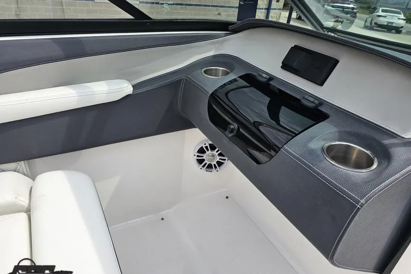 Slide: The Image of 2021 Regal LX4 boat interior with cup holders and speaker, featuring sleek design. - 56