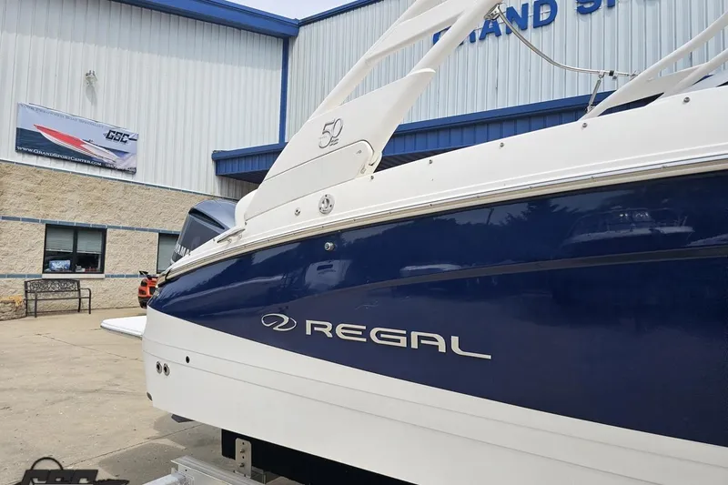 Slide: The Image of 2021 Regal LX4 boat displayed outside a showroom, showcasing sleek design and branding. - 6