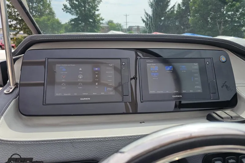 Slide: The Image of Dashboard of a 2021 Regal LX4 boat featuring dual Garmin displays. - 65